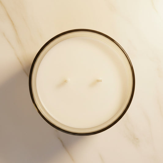 Top-down view of a candle with visible wick on a dark background
