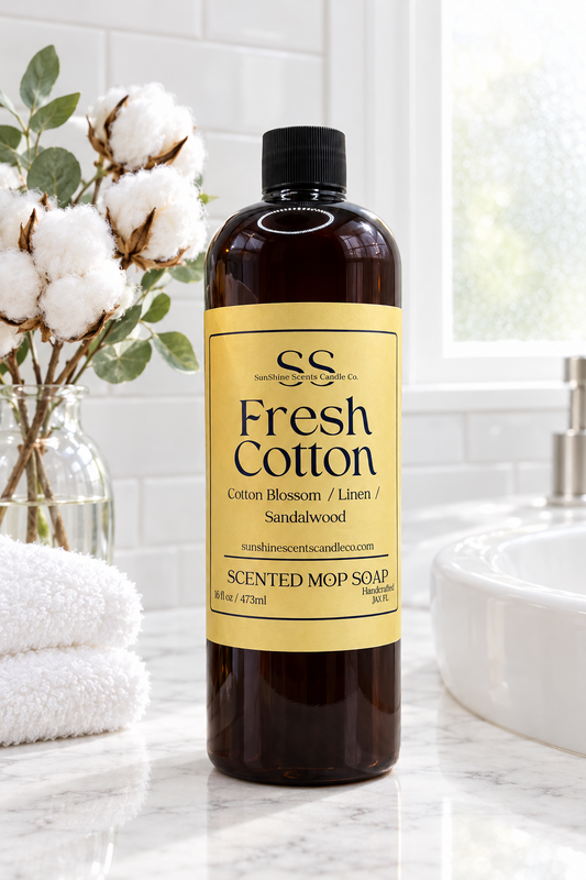 “SunShine Scents Candle Co. Fresh Cotton Mop Soap 16oz bottle on a bathroom counter beside white towels and cotton stems.”